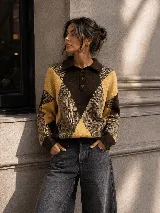 Sweater de tejido de punto con cuello polo y cierre frontal parcial con tres botones. Presenta un diseño geométrico de rombos en tonos marrón, amarillo y tostado, con mangas largas y puños ribeteados.