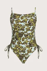 Traje de baño enterizo con estampado animal print en tonos verde y celeste. Presenta breteles finos, incrustaciones de tachas metálicas en la parte superior y jaretas laterales ajustables.