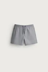Short de baño confeccionado en tejido técnico con patrón de rayas verticales en tonos azul marino y blanco, con cintura elástica ajustable mediante cordón y bolsillos laterales.