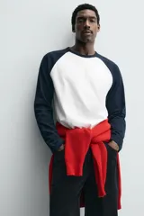 Camiseta de corte relajado con cuello redondo y mangas largas tipo raglán en contraste de color.