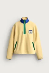 Sudadera polar de corte regular color amarillo, con cuello subido en tono azul, cierre frontal de cremallera verde y bolsillos con ribete verde. Incluye un parche gráfico de Fruit of the Loom en el pecho.