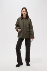 Campera de algodón estilo field jacket en color verde oliva, con cuello de pana en contraste color marrón, cierre frontal oculto y bolsillos delanteros amplios.
