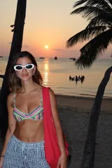 Conjunto de bikini con estampado de rayas multicolores. El top presenta un diseño con aros y breteles finos, mientras que la bombacha es de corte clásico.