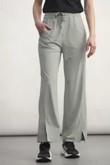 Pantalón gris de corte ancho con cintura elastizada con cordón ajustable, bolsillos laterales y aberturas en el ruedo.