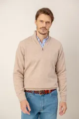 Sweater de lana lambswool color beige, con cuello alto y medio cierre frontal. Presenta puños y ruedo acanalados.