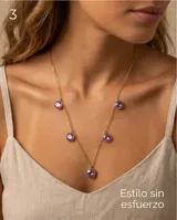 Collar de cadena fina dorada con cinco dijes colgantes redondos de cristal facetado en tono violeta tornasolado.