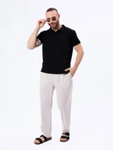 Remera polo negra de tejido cloqué, con cuello camisero, manga corta y calce cómodo.