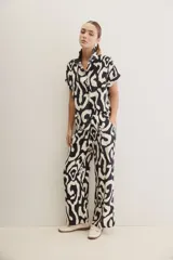 Pantalón ancho de corte amplio y fluido, con cintura elastizada y lazo ajustable. Presenta un diseño estampado en color blanco y negro.