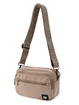 Bandolera compacta de lona color beige, con tres compartimentos frontales con cierre metálico. Incluye una correa ajustable con el logo de la marca estampado y un parche con el logo en la parte inferior.