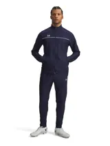 Conjunto deportivo Under Armour de hombre, compuesto por campera y pantalón en color azul marino. La campera presenta cierre frontal completo, cuello alto y detalles de líneas blancas en el pecho con el logo de la marca. El pantalón cuenta con cintura elástica y calce cómodo ideal para entrenamiento.