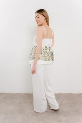 Pantalón blanco con estampado geométrico en azul y marrón, de calce relajado y caída fluida.