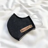 Tapabocas negro con etiqueta con la marca "Valente".