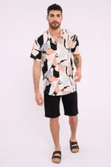 Camisa de manga corta con cuello clásico y estampado abstracto en tonos blanco, negro, gris y naranja.