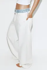 Jeans rectos de tiro medio en color blanco, con diseño de doble cinturilla en tejido denim a contraste, bolsillos y cierre frontal con cremallera y botones.