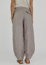 Pantalon de lino color beige, de corte recto y holgado, con cintura alta y ruedo con doblez.