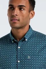Camisa de manga larga para hombre, color azul oscuro con un microestampado geométrico en tonos turquesa y blanco. Presenta cuello button-down con botones blancos y un pequeño logo bordado en el pecho.