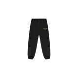 Pantalón de jogging Fear of God Essentials de felpa en color negro, con cintura elástica con cordones largos ajustables y puños elastizados en los tobillos. Presenta el texto "Fear of God State" estampado en dorado en la pierna izquierda.