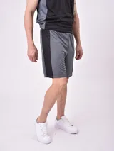Short deportivo de corte recto, color gris con franjas laterales negras. Confeccionado en tejido técnico transpirable, ideal para entrenamiento.