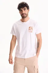 Remera blanca de manga corta y cuello redondo, confeccionada en 100% algodón, con un pequeño estampado minimalista en marrón en el pecho que incluye figuras geométricas, una palmera y olas.