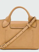Cartera tipo tote en tamaño extra pequeño, confeccionada en cuero de color verde oliva. Presenta una estructura rígida con asas cortas redondeadas y un cierre de solapa con broche metálico dorado grabado con el logo de la marca.