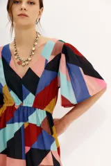 Vestido midi de gasa estampada con diseño geométrico multicolor, mangas cortas, elástico en la cintura, tajo frontal y forrería en la falda.