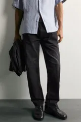 Jeans regular fit confeccionados en denim de algodón celeste con efecto lavado, de cinco bolsillos y cierre frontal con cremallera y botón.