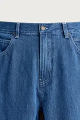 Jeans loose fit de tiro medio, confeccionados en denim de algodón color azul con efecto lavado. Presentan diseño de cinco bolsillos, bolsillo plastrón estilo carpintero en la pierna y cierre frontal con cremallera y botón.