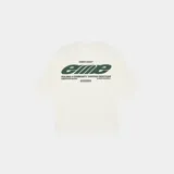 Remera oversized color blanco crema, con cuello redondo y mangas cortas. Presenta un estampado en la espalda con el logo de "Eme Studios" en verde y texto "Building a community through gratitude".