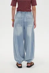 Pantalón jean de corte globo con cintura elástica y cordón ajustable, tiro medio y botamangas fruncidas con elástico.