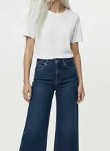 Pantalón de jean ancho (wide leg) de tiro alto, color azul oscuro (dark blue denim), con cierre frontal y bolsillos delanteros y traseros funcionales.