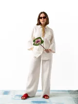 Pantalón de lino blanco de corte holgado, con cintura elástica ajustable con cordón, dos bolsillos laterales y un bolsillo trasero.