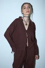 Camisa marrón de manga larga con cuello y escote en V que se cierra mediante lazos frontales.