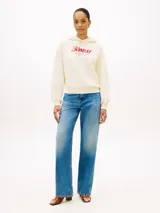 Buzo con capucha Tommy Hilfiger de color blanco, confeccionado en felpa de puro algodón. Presenta un corte amplio con hombros caídos, puños y bajo de punto canalé, y cordón ajustable en la capucha. En el pecho destaca un logotipo texturizado en tono rojo, complementado con un pequeño logo bordado en el puño.