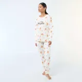 Pijama de dos piezas compuesto por una remera de manga larga y pantalón largo, confeccionado en algodón color blanco con estampado de Winnie the Pooh y corazones rojos.